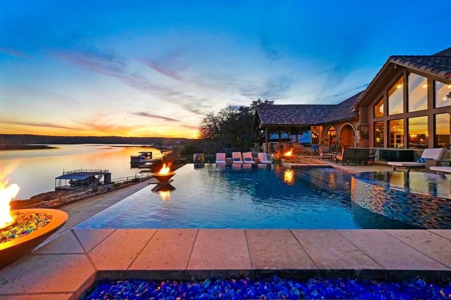 Welcome to the Finest in LUXURY LAKE LIVING at PK. This Spectacular Waterfront, Custom 6500SqFt, 6Bd,6Ba Home on 1.3 Private Acres, with Deep Water Dock, & 3 Car Garage, was Designed with Exceptional Lake Entertaining in mind. It offers Breathtaking Panoramic Views of Possum Kingdom Lake, and the surrounding Hill Country, with Stunning Sunrises and Sunsets, and the Best in Lake Recreation Fun, all from your Lake Side Retreat, complete with Infinity Pool and Spa, Outdoor Dining Area, and Kitchen, in the Resort Style Luxe backyard. This Estate Home features Walls of Picture Windows and Cathedral Ceilings with Custom brick, stone & warm wood work throughout, with 2 Master Bedrooms on the 1st level, Family Media Room, Office, Wet Bar and Gourmet Kitchen, & 3 Guest Rooms and Bunk Room on the 2nd Level. The Home also is equipped with high end Smart Home Sound, Lighting and Security Amenities, all within an exclusive Gated setting. No expense was spared to create this Phenomenal PK Paradise.