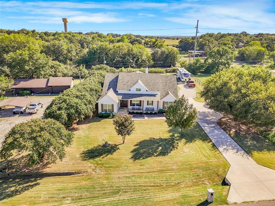 This magnificent 4-bedroom, 3-bath home was custom built in 2022 and is perfectly positioned on nearly an acre of land. Located within Mansfield ISD, but outside the city limits, the property offers a retreat that feels rural yet remains close to the city. Residents enjoy the added advantages of no city taxes or HOA restrictions, allowing full enjoyment and flexibility with the property.

Guests are greeted by an inviting front porch, and elegant double front doors that open into a spacious entry hallway. Designed for comfort and practicality, to the left of the entry hall are two bedrooms connected by a Jack and Jill bathroom. On the right, a versatile room with French doors and a closet can serve as a home office or an additional bedroom.

The entry hallway leads into an expansive family room, kitchen, and dining area with an open-concept design—ideal for entertaining or everyday living. The elegant kitchen is equipped with an oversized island, abundant cabinet space, a large walk-in pantry, and a spacious dining area, making it well-suited for hosting gatherings of any size.

Enjoy the striking white stone fireplace in the family room and the beautiful bank of windows along the back of the home, which provide plenty of natural light and picturesque views. The large covered back porch offers additional space for relaxation and direct access to the generous backyard. The private primary suite features a luxurious ensuite bath and a huge walk-in closet, ensuring comfort and convenience for homeowners.

This property includes a spacious driveway, a three-car garage, and the bonus of an RV pad with full utility services, accommodating multiple vehicles and recreational needs with ease. Schedule today to see this exceptional property that offers the perfect combination of style, space, and location.
