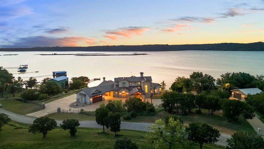 Gorgeous lakefront property with panoramic views of Possum Kingdom Lake. Drive up to this gated home with a grand porte cochere at the main entrance and plenty of parking for guests. Spacious, open concept kitchen and living space with floor to ceiling sliders in the living room and two main level primary bedrooms provide breathtaking views. Upstairs, a second living area with pool table, upper level deck and two bedrooms each with a built out secret attic space and sleeping for eight. The backyard pool has an electric cover for easy maintenance, surrounded by turf and an outside shower. The oversized drive-through garage is perfect for storing a large boat, waverunners, ATVs and more! Incredible backyard patio with wooden vaulted ceilings, fireplace, outdoor kitchen and eating area is ideal for entertaining family and friends. Whether you are relaxing on the patio, swimming in the pool, soaking in the sun on the dock or sitting around the fire pit, this property is designed for the perfect lakefront gatherings!