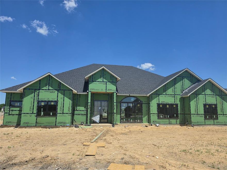 Scheduled for completion in July-August 2026, this one story transitional estate by JBM Custom Homes is designed to be experienced, not just seen. From the moment you step inside, graceful full radius arches draw you forward into a breathtaking living space where 30 foot vaulted ceilings soar overhead & a gas fireplace creates a warm, inviting focal point. Natural light fills the home, highlighting the thoughtful craftsmanship & effortless flow from room to room. At the center of the home, the kitchen becomes a place to gather. Quartz countertops, two expansive 10 foot islands with dual sinks, & a panel ready built in Z Line refrigerator make both everyday living & entertaining feel seamless. Just beyond, a walk in butler’s pantry with an additional refrigerator, sink, & ice maker keeps everything perfectly organized & out of sight. The primary suite is a true retreat, offering its own vaulted ceiling, a quiet sitting area, & a spa inspired bath with a freestanding soaking tub & oversized walk in shower. The impressive 330 square foot closet, complete with dual islands, feels more like a private boutique than a closet. Four additional bedrooms each feature ensuite baths & walk in closets, while a study with built in cabinetry & a media room with wet bar provide spaces to work, unwind, & entertain. Outdoor living is just as intentional, with a covered patio featuring a gas fireplace, TV wiring, & a built in outdoor kitchen designed for evenings under the stars. Built with 2x6 framing, spray foam insulation, natural gas throughout, EV charging, advanced AV wiring, whole home surge protection, Aerobic sewer, & premium Delta plumbing fixtures, this home blends luxury, comfort, & modern efficiency. A two car garage, separate one car garage, & porte-cochère, this exceptional home is ready to be your future.