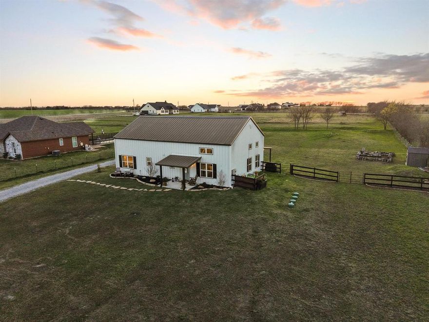 OPEN HOUSE ~ Sunday, 3-22, 2pm-4pm ~ Life slows down as the sky turns golden—unwind in your own private outdoor oasis featuring a cozy firepit and expansive porches designed for soaking in breathtaking horizon views. Escape the limitations and embrace true independence with this one-of-a-kind barndominium, perfectly situated on fully fenced and gated, 1.5 acres with no HOA. Whether you envision building a shop, parking your RV, or simply enjoying wide-open space, the possibilities are yours. The classic front porch offers a warm welcome and a glimpse into the thoughtfully designed interior. Inside, the heart of the home showcases an open-concept layout where the kitchen, dining, and living areas come together seamlessly, highlighted by dramatic ceiling heights and beautifully complementary finishes. The inviting living room flows effortlessly into the dining space and kitchen, feels inviting and can accomodate a crowd. Designed with both style and function in mind, the kitchen is a true showpiece—complete with a large island, abundant storage, and a dream-worthy walk-in pantry. The spacious primary suite is a relaxing retreat, featuring a spa-like ensuite with dual sinks and a walk-in shower. Three bedrooms, including the primary suite, are conveniently located on the main level. Upstairs, you’ll find a private fourth bedroom along with a second living area and a versatile flex space perfect for a home office, playroom, or media room. Step outside to the patio, the perfect spot to unwind and take in endless country views. Enjoy the best of both worlds—peaceful rural living with convenient access to nearby amenities, including shopping and dining in McKinney, Greenville or the new HEB in Melissa.