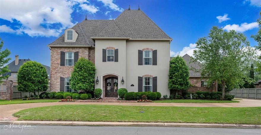 Immaculate custom home in Southern Trace. Reclaimed brick accents & grand staircase with stunning wrought ironwork greet you at entry. Wine room with wood beams, fireplace, bev fridge &wine storage. Downstairs guest suite. Formal Dining w butler's pantry. Chef's kitchen features to-the-ceiling cabinetry, SS appliances,built-in fridge,gas cooktop,double ovens,massive island w seating & storage.Walk-in pantry. Breakfast room offers additional seating. Living room w tall windows welcome beautiful natural light. Powder room. Lovely side courtyard w fountain. Spacious utility w sink & space for 2nd fridge.Mud bench off of 3-car garage. Private, downstairs master suite boasts a fireplace, coffered ceiling, soaking tub, separate vanities w vanity seat, large walk-in closet &door out to rear porch.Outdoor living center w built-in gas grill.Large fenced yard. Wonderful upstairs living space + 2 beds w ensuite baths.Flex room, for future playroom or storage. Single owner, meticulously cared for.