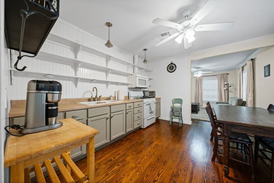 Charming 2-bedroom, 1-bathroom pier and beam home built in the 1950s in Hillsboro, Texas! This 784 square foot home sits on a 0.14 acre lot and was comprehensively updated in 2011 with new sheetrock, new electric, new plumbing, and the bathroom was also updated. The roof was replaced in 2018 for added peace of mind. The home features beautiful original hardwood floors throughout and new windows for improved efficiency. The kitchen includes open shelving and a gas range, creating a functional and stylish cooking space. Central air and heat provide year-round comfort, and the home has an electric hot water heater. All appliances convey with the sale, including the gas range, refrigerator, washer, dryer, and the baking racks in the laundry room house will stay with the property. The backyard features a deck perfect for outdoor relaxation, mature pecan trees providing shade, and a storage building that would make a great she shed or man cave. The property includes a covered 1-car carport with privacy fencing on 3 sides. This well-maintained home combines vintage charm with modern updates, making it perfect for first-time buyers or anyone seeking an efficient, manageable home in Hillsboro!