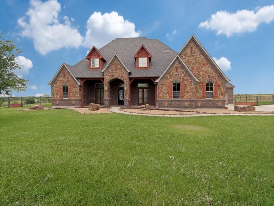 Custom-built luxury home situated on 2.09 acres in the desirable Vista Ranch community, featuring soaring ceilings, beautiful hardwood floors, 4 bedrooms, 3 full baths, and 1 half bath, a formal dining area, and a private office. The main living area is anchored by a stunning floor-to-ceiling stone fireplace, complemented by custom built-in cabinetry, creating a warm and inviting focal point. The gourmet kitchen offers custom wood cabinetry, granite countertops, a center island with prep sink, gas cooktop, decorative vent hood, double ovens, a walk-in pantry, abundant counter space, and an open flow to the living and dining areas. A dedicated wine room with a decorative iron door and custom built-in wine storage adds an elegant touch.  Upstairs offers a media room and a spacious game room with a wet bar, enhanced by custom cabinetry throughout, along with a convenient half bath.  Enjoy the expansive covered back patio with a floor-to-ceiling stone fireplace, outdoor kitchen, and peaceful acreage views. Car enthusiasts will appreciate the 5-car garage, including a drive-through bay for added convenience. A standout feature is the impressive 38x47 detached shop with warehouse-style space, complete with a 12x12 overhead door, soaring ceilings, concrete flooring, and an open-span layout—ideal for car collections, RV or boat storage, or a premium workshop. Located in the highly sought-after Northwest ISD.  All information is deemed reliable but not guaranteed and should be independently verified by the buyer and buyer’s agent. All measurements are approximate.