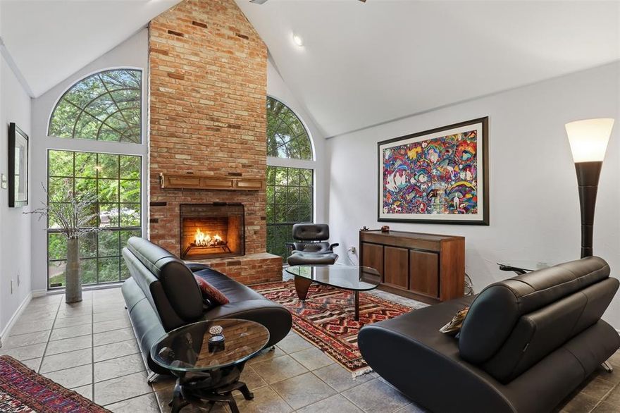 Nestled among a canopy of mature trees, this one-of-a-kind home offers privacy, charm, and stunning natural surroundings. The main level is filled with expansive windows that beautifully frame the scenery, bringing in abundant natural light and creating a seamless connection to the outdoors.  Architecturally distinctive and unlike any other home in the area, this property showcases unique design elements paired with thoughtful functionality. Storage throughout the home is exceptional, and the property has been meticulously maintained. The spacious wraparound patio provide the perfect setting for large gatherings or a serene outdoor retreat where the only sounds you’ll hear are birds in the trees. Parking is plentiful with a large carport that easily accommodates two vehicles in addition to the attached two-car garage. Inside, the flexible layout features two living areas, one on each level, offering comfort and privacy for everyone. The kitchen is equipped with a high-end induction oven for efficient and enjoyable cooking, and the refrigerator, washer, and dryer will convey with the home. The primary suite is a true retreat, complete with a cozy wood-burning fireplace and a spa-like bathroom featuring a round jetted tub, separate shower, and beautiful stained glass accents. Additional highlights include unique ceiling details that enhance the home’s character, a stained concrete floor made to look like wood, tankless water heater, and newer heating and air systems. The secondary bedrooms and a full bathroom are located on the base level, where a portion of the exterior wall is underground helping maintain cooler temperatures year round and adding to the home’s energy efficiency and comfort.