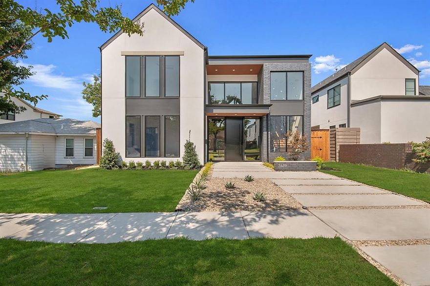 Experience elevated modern living in this newly built masterpiece, ideally located in one of Dallas’ most sought-after neighborhoods. The striking stucco and brick façade is enhanced by floor-to-ceiling aluminum windows, flooding the home with natural light and complementing its sleek, contemporary design. Inside, an open-concept layout with soaring ceilings, engineered hardwood floors, Taj Mahal natural stone throughout, and designer finishes creates a seamless flow. The heart of the home is the living and kitchen space, where a gas fireplace wrapped in Taj Mahal natural stone and a built-in wine rack set an inviting tone. The chef’s kitchen boasts a large waterfall island and countertops, hidden walk-in pantry, abundant cabinetry, Sub-Zero, Wolf, Cove appliances, gas cooktop, and Kohler pot filler. The first-floor primary suite offers private backyard access and a spa-like en-suite with floating vanity, walk-in shower, free-standing tub framed by a dramatic accent wall and surrounded by stone rocks, and a custom closet with center island and floor-to-ceiling storage. Also downstairs are a paneled office, a mother-in-law suite with private bath, and a laundry room with sink and chute connecting to both upstairs closets. Upstairs, a versatile game room or flex space with an outdoor balcony joins two additional bedrooms—each with its own bath and walk-in closet. The backyard is perfect for entertaining, featuring a fully equipped outdoor kitchen with Blaze appliances, sink, tiled flooring, and a gated rear entrance. Ample lawn space offers the opportunity to add a pool or customize your outdoor retreat. This energy-efficient, eco-smart home includes foam insulation, hot and cold exterior hose bibs, two Navien tankless water heaters, NUVO water filtration, Tesla universal charger, HomePro security and more. Don't miss out on this new-construction gem!