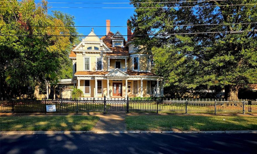 Stunning Queen Anne Victorian Architecture, curved wrap-around neo-classic porch, three gargoyles and a circular turret combine to give this home fantastic curb appeal.  Front metal fence with remote controlled gates, magnificent oak trees and several pecan trees on almost on acre. Two car garage, plus 2 car carport and a Porte-Cochere.  ELEVEN FIREPLACES all ORIGINAL!  Six bedrooms and 3 and a half baths.  This house was constructed in 1890 by Jethro Atkinson, bank director and owner of Paris' first shoe store and has been listed on the National Register of Historic Places since 1988. Amazingly this home survived the great fire of 1916 that occurred in Paris. Roof is approximately 8 years old, owner also replaced French doors and 42 windows with vinyl, double pane USA.  A list of improvements, repairs, and current concerns are available upon request.  Gorgeous hardwood floors and parquet flooring, multiple living areas and large walk in attic. Home is in need of repairs at this time and an estate sale is ongoing so please excuse the mess.  With some TLC, would make a wonderful bed & breakfast! Total acreage is .85.  Now is your chance to own a piece of Paris History!!