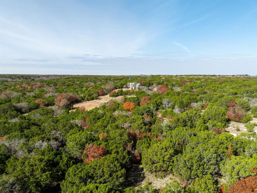 Situated on 26 acres ± in Bosque County, this custom home sits atop a hill offering breathtaking panoramic views of the surrounding countryside. The property features a stock tank and approximately 4 acres of open pasture, ideal for a food plot, livestock, or wildlife habitat, making it a fantastic recreational property for hunting, exploring, or peaceful country living.

Perched on the hill is an approximately 2,421 sq. ft. custom-built home, designed to take full advantage of its elevated setting, built in 2008. The house offers two bedrooms and two full bathrooms on the main level, along with a spacious loft upstairs featuring a full bathroom, perfect for guests, a home office, or additional living space.

The heart of the home features an open-concept kitchen, dining, and living area highlighted by a beautiful stone fireplace. Large windows in the dining and living rooms showcase stunning views and cathedral ceilings, seamlessly extending to the porch, creating an ideal space for outdoor entertaining and enjoying relaxing sunsets. The kitchen is thoughtfully designed with custom alder-wood cabinetry, stainless-steel appliances, granite countertops, a large gas range, a built-in microwave, a dishwasher, an expansive island with a sink, and a walk-in pantry.

The primary suite, located just off the kitchen, features vaulted ceilings and tall windows that capture the serene landscape. The primary bathroom offers a spa-like retreat with his-and-hers vanity areas, a soaking tub, a spacious walk-in shower, and a walk-in closet with a separate restroom area.
This quiet country property is conveniently located on paved FM 1238, just minutes from Iredell, Texas, with easy access to Hico via Highway 6. Nearby amenities include restaurants, grocery stores, pharmacies, medical clinics, boutiques, inns, entertainment, and more.

Don’t miss this opportunity; this exceptional Bosque County property is priced right and ready for its new owner.