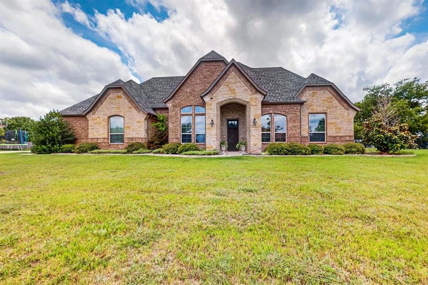 Experience country living miles from city in this fabulous one-acre property, where timeless design meets resort-style comfort. Thoughtfully positioned, this property offers unmatched privacy, tranquil surroundings, and an atmosphere. Feels like you are tucked away in much needed tranquility.  Inside, the home welcomes you with soaring ceilings, rich, wood flooring, and sun-filled spaces that create an effortless sense of luxury. The grand living room—anchored by a striking stone fireplace—opens to sweeping views of the pool and spacious backyard, setting the tone for everyday elegance.  The kitchen is designed for both culinary ease and family gatherings, featuring a spacious island, countertops, stainless steel appliances, and a generous walk-in pantry. A split-bedroom layout ensures privacy for all, with the primary suite offering a serene escape. Enjoy morning views of your private oasis and indulge in a spa-inspired bathroom complete with a soaking tub, walk-in shower, and dual vanities.  Great for families and retirees alike, the home includes a dedicated office at the entry,  a private upstairs entertainment, media, game room combo, with half bath, that is ideal for movie nights or game night. Outdoors, your personal paradise awaits with a sparkling pool and waterfall features, a spa, and outdoor fire pit area that creates an ambiance of pure relaxation and space for outdoor dining—offers an effortless environment for gatherings, celebrations, or quiet evenings under the stars. NO HOA, a 3-car garage, and Lake Ray Hubbard minutes away, lux living with the freedom to create the lifestyle you desire. Whether you're raising a family, enjoying retirement, or seeking a peaceful retreat with much comforts, this property delivers a blend of elegance, functionality, and natural beauty. Come take a look, welcome HOME to enjoy the morning sunshine to the Peaceful, scenic sunsets!
