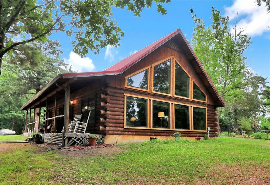 GATED ESTATE WITH A CUSTOM SATTERWHITE LOG CABIN HOME ON 16.5 ACS WITH TRAILS THROUGH-OUT. NO HOAs. TIMBER AG EXEMPTED. HUNTING AND WILDLIFE. RV CONNECTION. NEW Windows. NEW Filtered Gutters. Private Water Well System on the property. WITH newer purifying system. LOG CABIN HOME - BIG front porch. Landscaped. 2 bed, 2 bath, grand-room with wall of windows. Beautiful Kitchen with a gas range, frig, stove, & MW. Kitchen sink with precious views. It opens up to a Grand-room with dinning and Living-room with vaulted ceilings and giant windows providing panoramic views. Large laundry room with full W&D and room for a freezer & storage. 1 BR is down stairs with a bathroom, has 2 great size closets. 2nd bedroom upstairs in the loft area, hardwood floors, with a bathroom and exclusive balcony & a large closet with. Detached 2 car garage with extra storage. Very well kept & clean property. Plenty of parking space for entertaining. Come make it your own.

2ND QTRS
Currently being used as a business, but it has a bathroom and kitchen sink, fridge, and its own water heater & AC. Remodeled or repurpose for living qtrs.

PROPERTY FEATURES:
• Creek in the back & you could build a pond.
• 4 Additional structures on the property. 
• 250gal Propane Tank. 
• Underground electric.

Seller is retiring from his business so he will also sell his equipment.  Call or email for more details on that. Seller is also negotiable on other items on the property, just ask.
