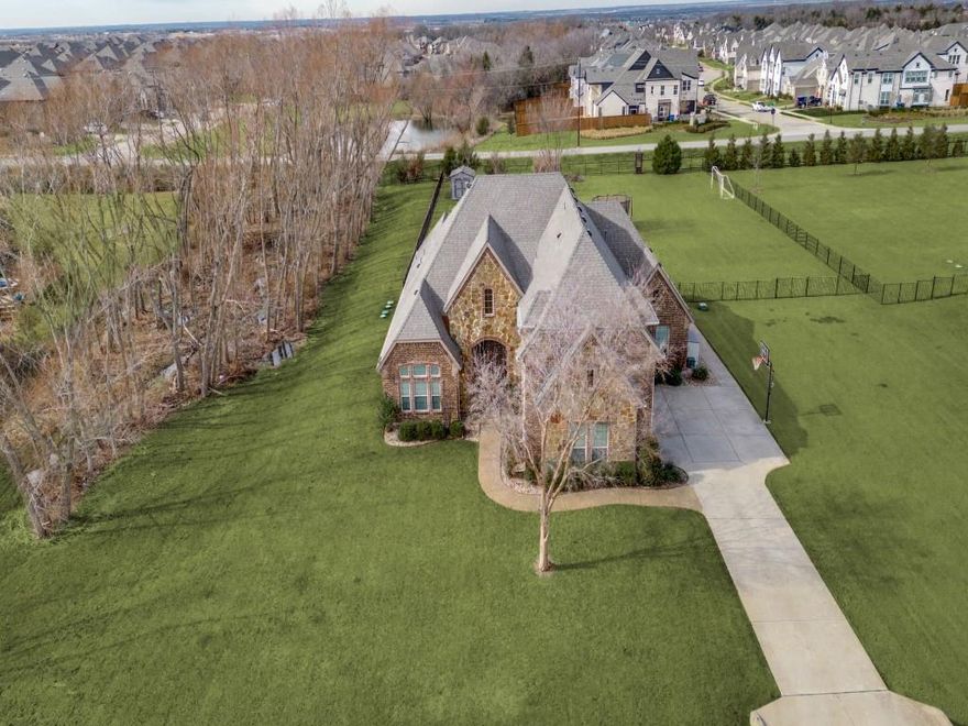 Nestled on a private, tree-lined 1.25-acre lot in Celina ISD and the highly sought-after DC Ranch community, this stunning home offers the perfect blend of luxury, privacy, and small-town charm. Featuring an open floor plan with soaring 12-foot ceilings, white oak hardwood floors, modern design theme, and abundant natural light, this home was thoughtfully designed for both everyday living and entertaining in mind. The spacious living room showcases a dramatic floor-to-ceiling stone fireplace and a wall of windows overlooking the expansive private backyard and pool. The chef’s kitchen is equipped with a gas cooktop, custom vented hood, double ovens, walk-in pantry, farmhouse sink, upgraded quartz countertops against light cabinets, subway tile backsplash, filtered water system, motion-sensor faucet and bar area with extra seating. A dedicated office with french doors and formal dining room offer front yard views, while the private primary suite is tucked away at the back of the home for added tranquility, and features an oversized bath with walk in shower, dual sinks and massive closet! All guest bedrooms are located on the main level and upstairs features a large game room or 2nd living area with a half bath. Additional highlights include a 3-car extra-deep garage, new roof and gutters in 2024, tankless water heaters, and smart thermostats. Step outside to your resort-style backyard featuring a pool, spa, covered patio with outdoor fireplace, built-in outdoor kitchen, mood lighting, and a large storage shed. With Celina High School just a short walk, bike, or golf cart ride away, this exceptional property offers convenience and peaceful country living. Minutes from shopping, dining, and entertainment in growing Celina and Prosper!