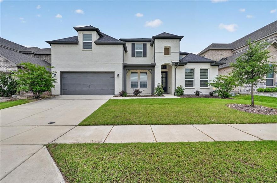 Experience elevated living in this stunning north facing 4-bedroom, 4 full bath, 3 car garage home with study, media and game room in the highly sought after Ridge at Northlake, zoned to exemplary Argyle ISD. From the striking white brick exterior to the light filled interior, this home blends modern elegance with everyday comfort. Soaring vaulted ceilings, rich wood flooring, and an open-concept design create a warm yet sophisticated atmosphere throughout.

At the heart of the home, the kitchen is a culinary dream with quartz countertops, under cabinet lighting, stainless steel appliances, a gas cooktop, and a walk-in pantry, all opening seamlessly to the living and dining areas. Motorized blinds enhance these main spaces, while surround sound extends through the living room, game room, media room, and patio for effortless entertaining. Step outside to a large grassy backyard with an extended covered patio, perfect for relaxing or hosting gatherings year-round.

The first floor offers a thoughtfully designed layout featuring the primary suite, a private study, spacious mudroom, a secondary guest bedroom and a full bath down, ideal for multi-generational living or hosting. The extended primary suite is a true retreat, complete with an oversized closet and a dreamy primary bath designed for relaxation. Upstairs, you’ll find two additional bedrooms, two full baths, along with a spacious game room and dedicated media room, creating the perfect setup for family living and entertaining.

Nestled against a greenbelt and within walking distance to an elementary school and resort style community amenities including a playground, fitness center, park, pool, and splash pad, this home offers the perfect blend of tranquility and accessibility. Conveniently located near major highways, shopping, and dining, bringing together comfort, design, and daily convenience.