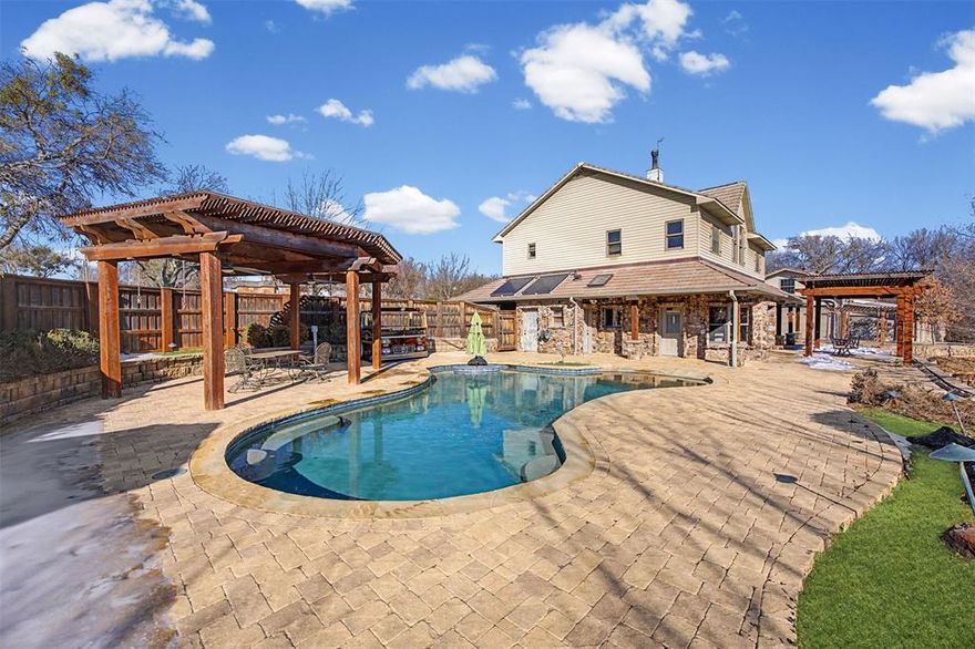 it's a MUST TOUR to appreciate!A True Texas Legacy – Award-Winning Timber Frame Estate on over 3 Acres in the Aledo ISD. Built and cherished by a one owner family,this extraordinary property is more than a home—it’s a legacy. Rich in history and craftsmanship, this remarkable residence is a true testament to its architectural distinction and enduring quality.This stunning two-story home showcases breathtaking features throughout the interior, blending rustic elegance with timeless design.A wood-burning stove beautifully connects the kitchen and living room, creating warmth and ambiance at the heart of the home. The spacious primary suite upstairs offers a peaceful retreat complete with a private ensuite bath,while an optional secondary primary suite on the main floor—also with a full ensuite bath—provides flexibility for guests or multi-generational living. Large windows throughout flood the home with natural light, highlighting the genuine craftsmanship. 
Step outside to your own private oasis featuring an outdoor pool surrounded by an expansive stone-laid patio. Two pergolas both enhance the outdoor living experience—one poolside and another on the back porch overlooking a serene seasonal pond.For all those who enjoy a shop that has it all-includes a large hand built wood stove and 4 mini splits keeping it nice and cool or warm for all seasons working on those projects.also entails a glassed porch area overlooking the property;Upstairs is a full guest quarters consisting of 2 bedrooms, a full bathroom, bath-shower combo;downstairs includes an additional full bath with shower, and full sized washer-dryer area. The second shop, another area with plenty of space to work on automobiles or projects,comes with plenty of storage. This property includes 3 large solar panels,totally paid for, that result in very attractive utility bills throughout the year. TThe list goes on and the features are endless in this home! Schedule your showing today!