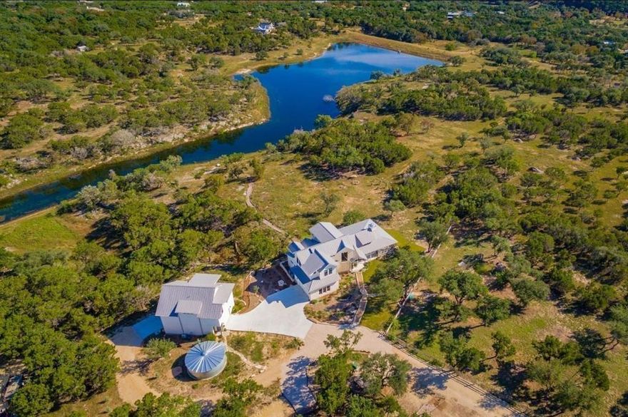 WOW!! Come see this elegant WATERFRONT estate in Wimberley, TX. This beautiful Modern Farmhouse was a 2019 Max Award Finalist! Its unique design, exceptional details, and custom craftsmanship welcome you to this serene home. This estate consists of a main house of approximately 3055 sq ft and a guest house of approximately 1439 sq ft, all on 8.45 lakefront acres on Mustang Valley Lake. Some of the highlights found in the main house include custom light fixtures, exposed beams, handmade tiles from Tabarka Studios, and a gorgeous kitchen island with a cherry wood top. The stunning screen porch will make dining al fresco a nightly pleasure! The guest house continues with the same fine materials – wood-grain tile floors, granite and quartz counters, and expansive windows. The balcony deck is a great place to enjoy the impressive lake views, birdwatch, and relax! (See attached extensive feature list for more details on materials and construction).