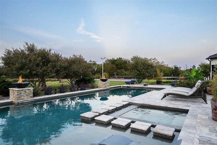 Experience the ultimate in luxury, privacy, and comfort at this stunning gated estate on 6.5 acres in Tacoma Ranch. This thoughtfully designed one-and-a-half-story home offers most living spaces conveniently on the main floor, with folding doors connecting indoor and outdoor areas for a bright, open atmosphere—perfect for entertaining or relaxing in peace.
The chef’s kitchen is a culinary dream, featuring commercial-grade appliances, a built-in refrigerator, a spacious island, and rich natural wood finishes. The open floor plan flows effortlessly through multiple living areas, enhanced by decorative lighting, double vanities, and a state-of-the-art smart home system.
Step outside to your private resort-style oasis, meticulously upgraded by the seller with top-of-the-line pavers, lush landscaping, a pool, spa, and sport court. The outdoor kitchen, complete with BBQ, fireplace, and covered patio, makes entertaining effortless. Quality-built fencing, a tranquil pond with sprinkler system, and expansive grounds create a serene, private environment.
Additional luxury features include a metal roof, electric shades, energy-efficient systems, generator, and a garage with two storage lifts. Every detail of this estate reflects the highest level of craftsmanship and thoughtful investment—perfect for those seeking both grandeur and comfortable, mostly single-level living.