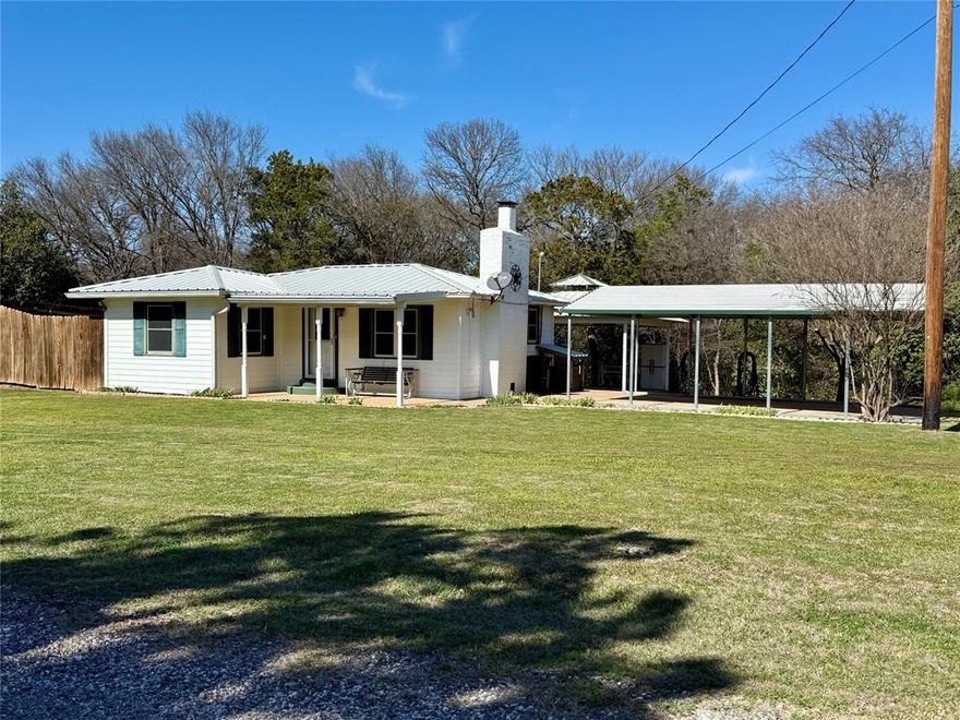 Come kick back and enjoy life on Lake Whitney! This place has been well taken care of and is ready for its next chapter. The cabin has 2 bedrooms, 1 bath, and an open living area with a nice fireplace.  Just right for a retiree, weekend getaway, or first-time buyer.  Newer roof, solar screens and a recently replaced central air and heat.  Out back, you’ve got a nice deck and a big canopy that’s perfect for grilling, relaxing, or having friends over. There are plenty of extras too: a small garage that’s been turned into a laundry room, another garage with a closet, and an oversized carport that’s great for parking your boat.  With the right offer there’s even a side lot with full RV hookups for guests, extra space, or extra income. The property backs up to Corps land, and it’s just about a five-minute walk down to the water. Tucked away on a quiet dead-end road, it’s a peaceful little spot.  Come take a look and see if it feels like home.
