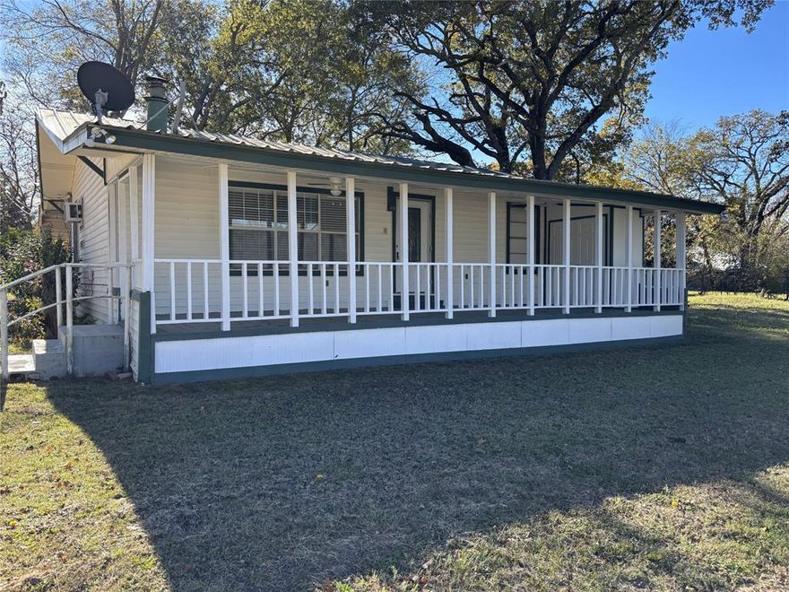 Charming home with fresh paint and flooring throughout.  2 Bedroom, 1 Bath, 1 Car Carport on a corner lot with a Lake View.  Laminate flooring, window units and wood burning stove.  Large covered front porch and short walking distance to enjoy Lake Tawakoni.