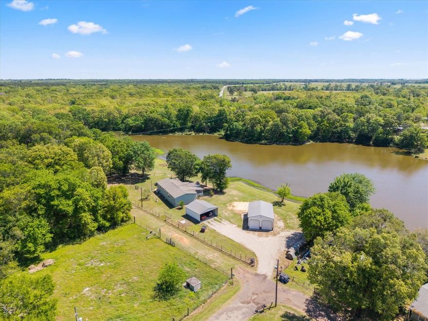 Experience the charm of East Texas living with this waterfront property, perfectly situated on six spacious lots with NO HOA. This 3-bedroom, 2 full bathroom home offers 1,560 square feet of thoughtfully designed living space with an open floor plan that seamlessly connects the living room, kitchen, and dining area—ideal for both everyday living and entertaining. Enjoy breathtaking lake views from every room, bringing natural beauty and tranquility into your daily life. Step outside to a screened-in porch complete with an outdoor fireplace—the perfect spot to relax while taking in the peaceful surroundings filled with birds and deer.  The property is packed with features for comfort, convenience, and peace of mind, including a utility room, underground storm shelter, security cameras, and extra storage space. A 2-car carport provides ample covered parking. For hobbyists or those needing workspace, the impressive 24x34 metal shop with three bay doors offers endless possibilities. Located near the renowned Lake Fork, famous for its world-class bass fishing, this home also provides easy access to Tyler and the DFW area, along with nearby shopping and amenities. This rare East Texas waterfront gem combines space, functionality, and natural beauty—schedule your showing today and see it for yourself!
