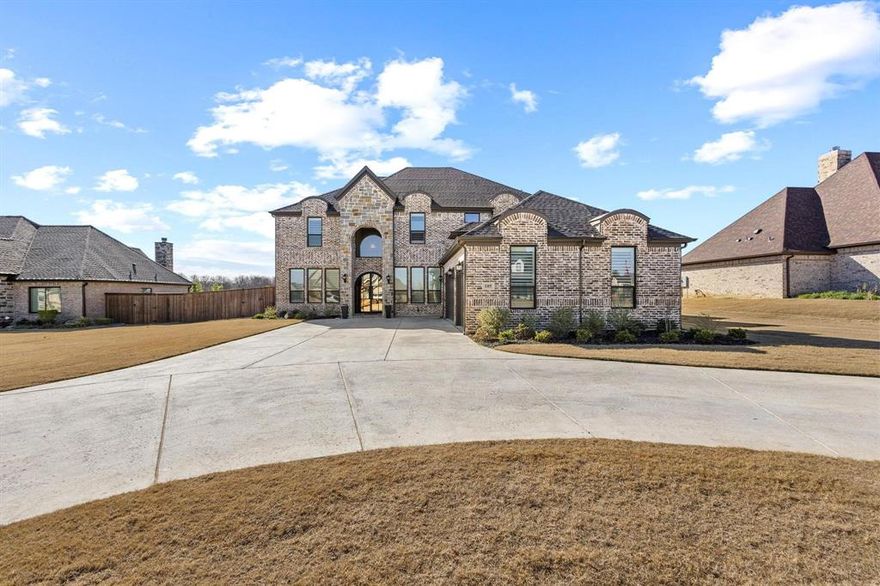 Welcome to 105 Shawnee Trail, located in one of Pottsboro’s most sought-after communities—just seconds to grocery, schools, and restaurants, and minutes from Lake Texoma.  This stunning 6 bed, 5 bath, 4,508 sq ft home on a half acre lot offers the perfect blend of luxury and everyday comfort. From the grand brick-and-stone exterior to the beautiful arched entry, this home delivers unforgettable first impressions. Inside, you’ll find a bright, open living space with soaring ceilings, wood beams, and a gorgeous stone fireplace. The chef’s kitchen features a 6-burner gas cooktop, double ovens, coffee bar, custom cabinetry, and an impressive 16' island—plus a hidden 6' x 13' walk-in pantry. A rare layout with two primary suites—one up and one down. The downstairs suite includes a 17' x 14' closet and serene backyard views. Additional highlights: 3-car garage, dedicated office, split bedroom design, exquisite finishes throughout.