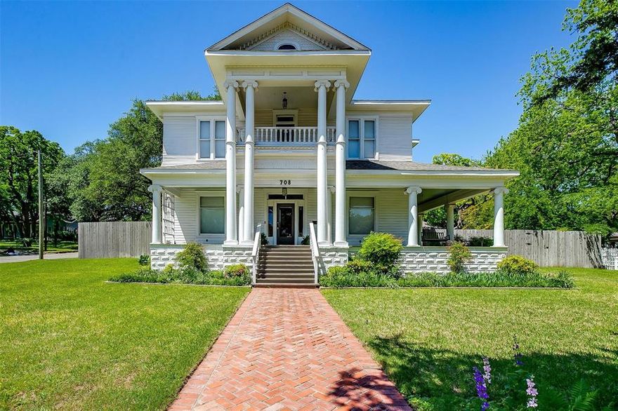 Step into history in this stately neoclassical home built in 1907 by Weatherford's first postmasters, the Milliken family. Nestled under a giant oak on a beautifully landscaped corner lot along the local parade route, this grand two-story home showcases timeless elegance.  It features signature doric columns on the exterior and intricate custom millwork in the foyer. Its wrap-around porch and two inviting balconies are perfect for enjoying morning coffee or evening sunsets.
Boasting 4 bedrooms and 3 baths, the home offers 4085 sq ft of charm and function. Historic character meets modern convenience with a new roof 2025, two AC units, foam-insulated attic and floor, and updated amenities throughout. Entertain guests in the formal parlor, make yourself cozy in the upstairs sunroom or library, take a luxurious soak in the 6' clawfoot tub, or tackle paperwork tasks in the dedicated office featuring custom built-ins and hidden pull-out desks. The spacious kitchen with butler's pantry and large formal dining room make hosting a breeze. 
Outdoors, enjoy a tranquil brick courtyard with a fountain, a 3-car detached garage with ample storage, an 8-ft privacy fence, and mature trees that offer beauty and deep shade. Located just blocks from downtown, the home is walkable to restaurants, shops, parks, and community events. Proximity to police and fire stations provides peace of mind. Rarely does a home blend historic pedigree with modern comfort so seamlessly.  Embrace this opportunity to own a prestigious piece of Weatherford’s True Texas heritage.

All information deemed reliable but not Guaranteed and should be independently verified by buyer and buyers agent.
