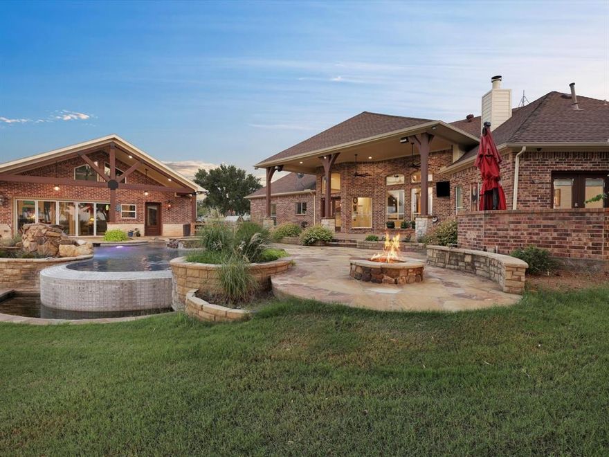 Exceptional equestrian property situated in the heart of Celina, Texas! This remarkable ranchette offers a diverse array of amenities to suit everyone. Enjoy amazoing sunsets from the comfort of this backyard retreat which features a cabana house, an infinity edge pool, a hot tub, and ample decking space, perfect for hosting many gatherings. For equestrian enthusiasts, the property includes a modern barn with stall spaces, a wash area, and separate, secure feed and tack rooms. Additionally, a well-lit riding arena and round pen are available for training and exercising horses, allowing for use during cooler Texas evenings. Spanning over 15 acres, this property includes lush grasslands, riding areas, and a stock pond, providing an ideal setting for your new home.
The home itslef features sweeping tall ceilings and a stacked stone fireplace in the heart. The master bedroom opens to a side private garden retreat area, perfect for morning coffee overlooking the pond and the pool.