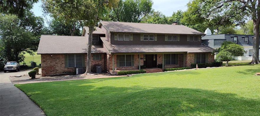 A rare opportunity to own a custom home backing to a creek & the 2nd fairway of the Golf Club of Dallas. Set on a generously sized lot & with no rear neighbors, the sense of privacy & open space is truly extraordinary. Tucked within a quiet, tree-lined neighborhood known for its architect-designed residences, this property offers a setting that feels miles away from the city.  The view is alive with nature. Evenings are often accompanied by the rhythmic sound of frogs along the creek, while daytime brings hawks—& occasionally eagles—gliding overhead. The uninterrupted expanse of the fairway creates a natural backdrop of rolling green, & a steady, cooling breeze frequently drifts across the course, adding to the peaceful, almost retreat-like atmosphere.  Inside, original details remain preserved, including brick flooring in the entry & sunken living room, rich tongue & groove paneling, 6-panel solid wood doors with brass & chrome hardware, & period light fixtures. Expansive windows along the rear of the home invite in abundant natural light & frame wide, unobstructed views of the course, creek, & surrounding greenery—blurring the line between indoor & outdoor living.  The flexible floor plan offers multiple options for primary living, with a spacious upstairs primary suite featuring elevated views, along with additional main or upper-level spaces that could function as alternative primary suites. Additional highlights include a dedicated office with lighted cabinetry, a butler’s pantry, a wet bar, in-law or service quarters with a bath, & generous closets with custom built-ins.  While the interior remains largely original, the exterior has been updated with Tyvek wrapping, Hardie board siding, & fresh paint—providing a durable foundation for future vision & enhancements. With its architectural pedigree, rare privacy, sweeping natural views, & exceptional potential, this home offers a truly distinctive living experience in a setting that feels both serene & inspiring.