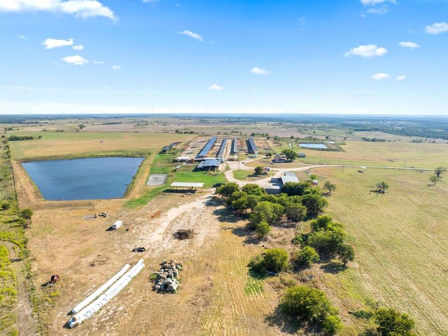 Exceptional opportunity to own a fully equipped commercial dairy on 221.944 acres in north-central Hamilton County, Texas. Conveniently located 12 miles north of Hamilton on FM 219, just 0.75 miles east of Hwy 281, this turnkey operation combines productivity, functionality, and room for expansion. The dairy is TCEQ-permitted for 2,000 total. Facilities include a 3,933 SF double10 Herringbone milking parlor, 3,500 SF covered holding pen, truck scales with 200 SF office. The operation also offers a 5,980 SF commodity barn with seven concrete bays and a 2,250 SF equipment barn. Additional features include two covered concrete feed lanes totaling over 24,000 SF, equipped with misters, stanchions, and water systems; an 8,000 SF hospital barn; nine cow shade structures totaling 52,000 SF; a 3,200 SF hay barn; and calf pens with metal sheds. The property is fenced and cross-fenced with pipe and cable, includes three wastewater retention ponds, three water wells, concrete drives, and buried water and drainage lines. Facility has maintained TCEQ compliance with upgraded retention capacity. Residential improvements include a brick home with 3 bedrooms, 2 baths, attached garage, carport, and storm cellar, plus employee living quarters. Two manufactured homes are also on-site for additional housing. The acreage consists of native and improved grasses with open pastures and functional layout for efficient operation. This Dairy presents a rare chance to acquire a high-capacity, permitted dairy with extensive infrastructure, reliable water, and housing ideal for continued dairy use or conversion to diversified agricultural operations.