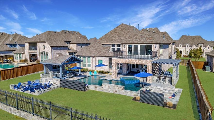 Luxury and resort-style living await in this stunning custom-built Huntington home, perfectly situated in the gated golf community of Balmerino at The Tribute on Lake Lewisville. Thoughtfully designed with high-end upgrades and exquisite craftsmanship. The grand foyer welcomes you with soaring ceilings and timeless architectural details. A private study with built-ins provides the perfect work-from-home retreat, while the first-floor media room is ready for movie nights. The formal dining room stuns with a wood-beamed ceiling, stone-accented walls, and a hidden bar with a built-in wine cooler, ideal for entertaining. The light-filled living room boasts vaulted ceilings, a striking fireplace, and breathtaking views of the backyard paradise. The gourmet kitchen is a chef’s dream, featuring commercial-grade appliances, a statement hood vent, a butler’s pantry, and an oversized island. A second office leads to the primary suite, offering a sitting area, spa-like ensuite with a massive walk-in shower, soaking tub, dual vanities, and a dream walk-in closet with laundry access. Upstairs, enjoy a sprawling game room with a bar and kitchenette, a flex space perfect for a gym or lounge, and spacious bedrooms, each with ensuite baths. A built-in desk area makes the upstairs office both stylish and functional. A 251 SF climate-controlled sunroom provides stunning views of the golf course and Lake Lewisville, creating the perfect space for relaxation year-round. Now, step outside to your resort-style backyard! Overlooking the golf course, this outdoor oasis features a sparkling pool and spa, multiple fire pits, an outdoor kitchen and bar, and a covered patio designed for year-round enjoyment. The oversized 3-car garage is built for convenience, with a 1.5-size third bay, a floored attic with an electric lift for easy storage, and an above-garage-door electric storage lift rack. This home offers access to world-class golf, pools, hiking trails, kayaking, and more.