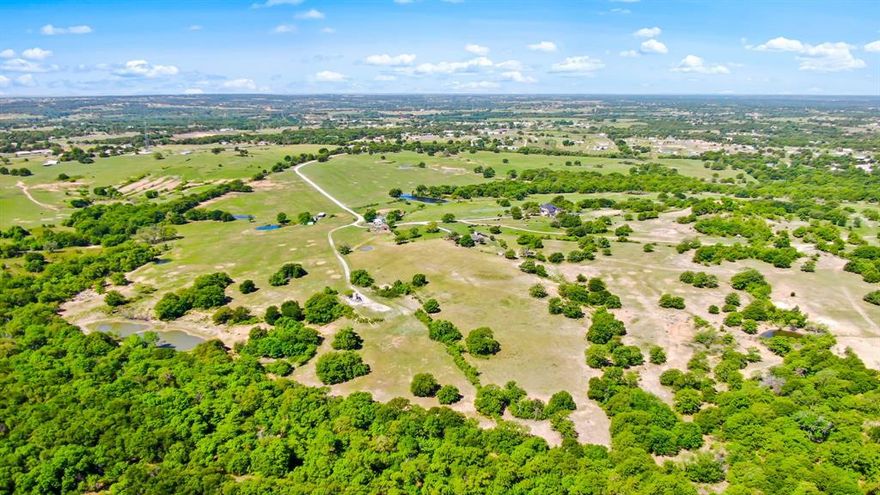 Discover the extraordinary beauty of this expansive ranch, boasting Skeen Peak, one of Parker County's highest elevations at 1224 ft! Currently utilized for cattle, recreation, and hunting, this property offers endless possibilities, whether for its existing purposes or for a development opportunity. With no floodplain or restrictions, vast stretches of lush pastures, two creeks—one spring-fed and flowing—complete fencing and cross-fencing, a 72' wide driveway entrance off 199, captivating topography changes, and over twenty ponds, this ranch is an oasis waiting to be explored. What's more, it's conveniently located just 50 minutes from downtown Fort Worth! The feasibility of connecting to Walnut Creek SUD can be confirmed with their engineer based on your desired use. A Trinity Country Listing Represented by Michael Moos