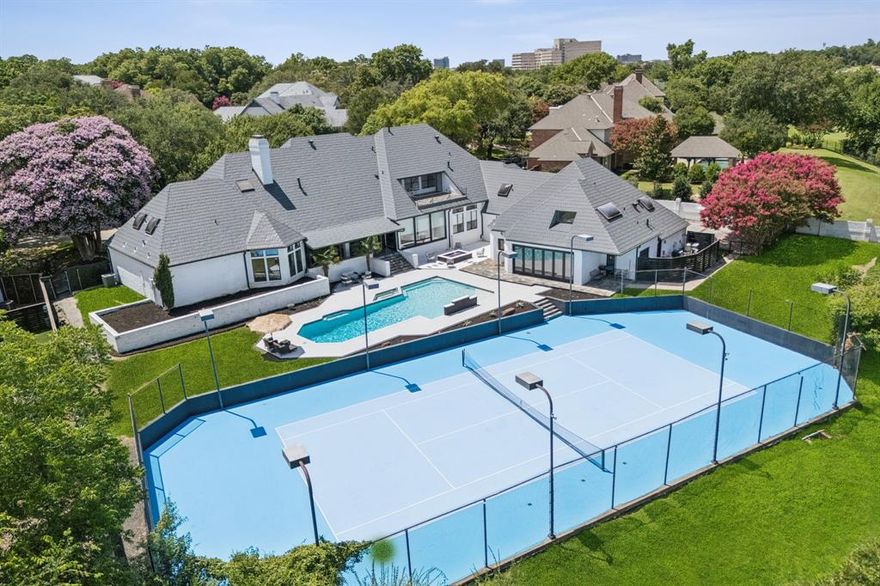 Executive Elegance Meets Resort-Style Living in Williamsburg Estates
Nestled on nearly one acre in the prestigious, tree-lined enclave of Williamsburg Estates, 14208 Hughes Lane is a 12,146 square foot estate designed for both grand entertaining and elevated family living. With its commanding presence and refined finishes throughout, this residence delivers the ideal balance of luxury, comfort, and seclusion—just minutes from Downtown Dallas.
Step inside to find multiple living and dining spaces, a true chef’s kitchen, executive study, game and media rooms, a home gym, and nanny quarters—all crafted with premium materials and thoughtful design. Soaring ceilings and custom architectural details enhance the home’s expansive yet intimate feel. Outdoors, this entertainer’s dream continues with a lighted tennis court, sparkling pool and spa, cascading waterfall, fire pit, and manicured greenbelt views—all in a private, executive-friendly neighborhood known for its large lots, peaceful setting, and close-knit community of high-level professionals. Whether hosting a formal dinner, a backyard celebration, or simply enjoying a quiet evening with family, this home offers the space, style, and sophistication to match any occasion.
