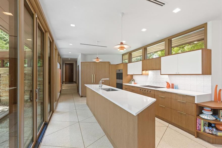 A Rare Architectural Masterpiece in Prestigious Overton Park. Nestled at the secluded end of Autumn Drive, this architectural marvel is a once-in-a-lifetime opportunity for the discerning buyer with an appreciation for design and artistry. Created by renowned Fort Worth architect Larry Morton Gernsbacher, AIA—a protégé of Frank Lloyd Wright’s Taliesin West—this mid-century modern masterpiece embodies geometric elegance, organic harmony, and timeless sophistication. Commissioned in 1957 by Leon and Fay Brachman, the 6-bedroom, 5-bathroom estate spans an impressive 6,387 square feet of intricately designed multi-level living space, accentuated by warm wood tones, custom stonework, and an abundance of built-in furnishings. Expansive walls of glass frame the lush canopy of mature trees, flooding the home with natural light while seamlessly blending indoor and outdoor living. The recently enhanced chef’s kitchen is a work of art in itself, featuring sleek custom cabinetry, top-of-the-line appliances, and a panoramic northwest-facing wall of windows, offering breathtaking views of the manicured grounds. A striking central stone fireplace anchors the dramatic great room, an awe-inspiring space that exemplifies depth, dimension, and architectural ingenuity. Designed for elevated entertaining, this estate boasts an outdoor oasis with a sparkling pool, a private firepit lounge, perfect for hosting gatherings beneath the Texas sky. A hidden wet bar, elegant formal and casual dining areas, and expansive open-concept interiors further enhance the home’s inviting yet sophisticated ambiance. Set on nearly an acre of pristine landscape, this estate offers unmatched privacy while being just minutes from upscale shopping, fine dining, and the vibrant cultural scene of Fort Worth. With its breathtaking design and seamless integration of nature and modern luxury, this home is a true architectural gem, awaiting its next curator to take it to the next level.