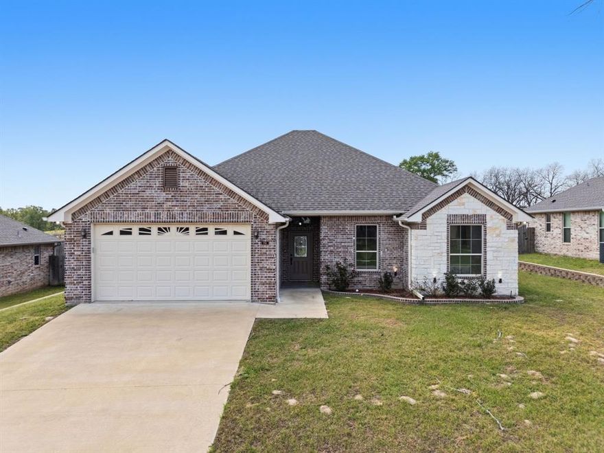Located in the desirable Nolan Farms community, this thoughtfully crafted 3-bedroom, 2-bath home blends timeless finishes with a layout designed for modern living. Completed in 2022, the home features a striking combination of brick and stone, complemented by classic rooflines and a welcoming front porch. Inside, the space opens up beautifully with vaulted ceilings and an easy, natural flow between the living, dining, and kitchen areas. The kitchen is both refined and functional, offering granite countertops, stainless steel appliances, custom cabinetry, and a generous island ideal for hosting or everyday life. The primary suite creates a true sense of retreat, complete with dual vanities, a soaking tub, a tiled shower, and well-sized walk-in closets. Additional highlights include luxury vinyl plank flooring, a sprinkler system, a two-car garage, and a fully fenced backyard ready for pets, play, or quiet evenings outdoors. With community features like a stocked pond, pavilion, and playground - and a location just minutes from Tyler and Lindale - this home offers a lifestyle that feels both elevated and convenient. Schedule your showing today!