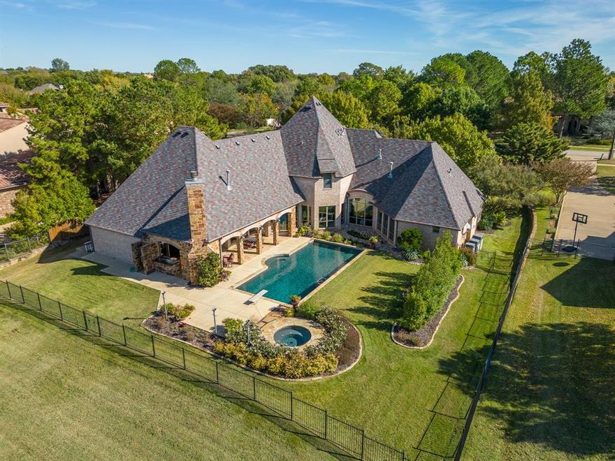 Spectacular custom home situated on tranquil 1.3 acres in Colleyville. Enter to hardwood flooring, stone & brick arches, & panoramic views of the resort-style back yard. Chef’s kitchen opens to family room & has Thermador SS appliances, exotic granite countertops, pot filler, & huge island with copper farmhouse sink & bar seating. Split bdrms provide a private owner’s retreat, also with views of the pool & back yard & offers a spa-like ensuite bath & large walk-in closet. Guest bedroom, private study, & mudroom also downstairs. Huge game room or media room upstairs. All bdrms have ensuite bath & walk-in closet including 5th bdrm or casita. Entertaining is a breeze with outdoor kitchen & living with stone fp overlooking the sparkling pool & separate spa - surrounded by lush landscaping - stocked pond with fountain & barn. Solar battery iron gate provides private access to 4 car garage & back yard access. Too much to list!