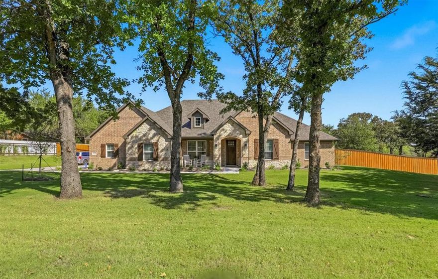 Beautifully situated along a serene country drive, this stunning property offers peaceful living with the convenience of daily amenities just minutes away and only 35 minutes from Fort Worth. Nestled on over an acre fully fenced, tree-filled lot, the home provides both privacy and picturesque surroundings.

Designed for comfortable one-level living, the home features four spacious bedrooms all providing large closet space and two and a half baths. The open-concept living is anchored by a striking Austin stone fireplace, creating a warm and inviting centerpiece for gathering and relaxation. A spacious eat-in kitchen with upgraded cabinetry and soft-close features flows seamlessly into the living area, while a formal dining room offers the perfect setting for special occasions. A large flex room just off the main living space provides endless possibilities for a media room, or playroom or simply additional space to spread out.

Windows spanning the entire back of the home fill the space with natural sunlight and showcase the beautifully maintained landscape beyond. The primary suite is a true retreat, complete with a generous sitting area framed by elegant bay windows. The en-suite bath features a large garden  tub, an oversized walk-in shower with a built-in bench, and an impressive walk-in closet.

Step outside to the expansive back porch—perfect for relaxing evenings and easily convertible to a screened-in outdoor living space. Thoughtful upgrades add both comfort and peace of mind, including a Generac whole-home generator powered by the included propane and tank so you’ll never lose power.

Additional highlights include a three-car garage with extra storage space and a storage shed purchased new in 2025 that will convey with the property.

This exceptional home blends elegance, comfort, and tranquil country living—making it a property you won’t want to miss.