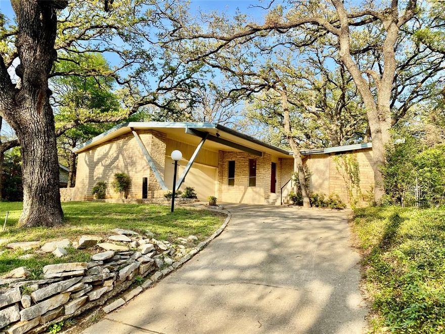 Welcome to 2013 Mill Creek Drive in The Heart of Arlington. This beautiful, unique mid-century modern home in Mill Creek Estates is nestled among the trees, giving you the whimsical feeling of living in a treehouse. Features flexible living spaces for relaxing and entertaining. Step into the formal living room and be immersed in the outdoors, floor to ceiling windows that bring nature right to you. The charming dining room is right off of the kitchen and features a wonderful built-in China cabinet and original MCM hardware and light fixture. With two living and two dining areas, this home offers plenty of space to spread out while remaining connected. The kitchen has spacious cabinetry, a large pantry, gas cooktop, and stainless steel appliances. The kitchen opens to the breakfast nook with original light fixture and to the large den which  features vaulted ceilings, a fireplace, sliding doors to a substantial patio, perfect for entertaining. The generous primary bedroom features three large windows and has an ensuite bathroom with a separate tub and shower and linen closet. The oversized walk-in primary closet is a functional space designed for optimal organization. It includes a separate smaller closet perfect for jewelry or other collections. The primary bedroom and hallway includes four additional closet spaces. The other bedrooms and the second bath are off of the family room and access to those can be closed off by an original wood pocket door. The fourth bedroom would be excellent for an additional living space, game room, theatre, office, or indoor workshop and features three closets. The abundance of custom storage space in this home makes it easy to stay organized. A new roof is coming soon and will stay true to the mid-century charm of this home. Outside the home, the charm continues. With several different spaces to enjoy on a large lot with many mature trees, there is plenty of space for entertaining,  and gardening.