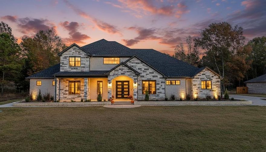 This stunning 4,650 sq ft home by Prime Home Builders sits on a 1-acre lot in Stone Chimney Cove, offering beautiful views of Stone Chimney Creek leading into Lake Palestine. The community features underground utilities, a private boat ramp and pier, a protected shoreline, and quick access to deep water. Located in the desirable Bullard School District, it’s also just fifteen minutes from groceries and essentials in the Bullard Hallmark Town area. Designed for luxury living, the home includes high-end kitchen appliances, Italian marble counters, and two refrigerator spaces. Enjoy covered front and back porches with tongue-and-groove ceilings, vaulted ceilings throughout, multiple living areas, and spacious bedrooms and bathrooms. The primary suite features an oversized luxury bathroom with double rain-shower heads. Recessed lighting and a hall-entry coffee bar add comfort and convenience. The oversized three-car garage offers 10-ft and 18-ft entrances, insulated doors, extended depth, and custom cabinetry. The expansive outdoor entertaining space includes an outdoor kitchen, powder room, and a large stone-hearth gas fireplace. Energy efficiency is enhanced by spray-foam insulation, two HVAC units, and tankless water heaters. Upstairs provides two attic access points with ample decked storage. The yard is nearly fully covered with upgraded St. Augustine grass and attractive landscaping, complemented by a picturesque front porch and beautifully finished steps. Built with exceptional attention to detail, this home is truly a must-see. The builder offers a 1-2-10 warranty and $10,000 in closing concessions for a rate buy-down or buyer’s choice.