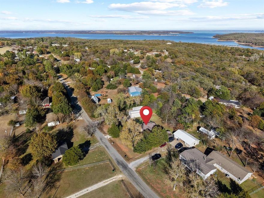 An incredible opportunity to own a versatile lake-area property awaits in this 2-bedroom, 2-bath home on 0.78 acres, located just 1 mile from Mill Creek Marina. 
From sipping your morning coffee on the porch to enjoying a relaxing stroll or golf cart ride to the lake and winding down by the fire pit, this property truly embodies the lake lifestyle you’ve been looking for—country living with natural surroundings! This home has also been a successful Airbnb, offering excellent potential for the next owner to continue using it as a vacation rental, a personal getaway, or both. All furniture, décor and dishware will convey with a favorable offer.
The spacious lot provides plenty of room for your imagination. With a circle drive, oversized shop and an additional covered boat storage, you’ll have space for all your toys and gear. Inside, the open floorplan features vinyl wood plank flooring and an updated kitchen. The mudroom includes full-size washer and dryer hookups, additional storage, and versatility as a potential bunkroom—complete with its own exterior entrance and bathroom.
Whether you’re seeking a peaceful retreat, an income-producing investment, or a full-time home near Lake Texoma, this property truly has it all. Make every day feel like a vacation on Cottonwood Lane!