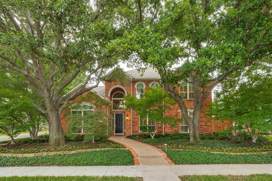 Situated beneath canopy of mature trees on a beautifully landscaped lot, this exceptional custom offers timeless architecture, quality craftsmanship, and an ideal layout for both everyday living and entertaining. A grand entry is flanked by formal living and dining spaces, showcasing rich hardwood flooring, soaring ceilings, and expansive windows with plantation shutters that frame serene views of the surrounding grounds. The thoughtfully designed floor plan includes a private downstairs bedroom with full bath, dual closets, and hardwood flooring, perfect for guests or multigenerational living. The remodeled chef’s kitchen is a true centerpiece, featuring commercial-grade appliances including a Wolf dual fuel gas range and oven and vent hood, SubZero refrigerator with water dispenser, warming drawers, vegetable sink, wine fridge, and an oversized island. Custom cabinetry with glass uppers and lighting, spice drawers, pull-out pantry storage, and Hafele corner systems provide both beauty and function. The kitchen opens seamlessly to the main living area with views of the backyard oasis. The primary suite is privately situated with peaceful backyard views, a sitting area, and a luxurious bath offering separate vanities with knee space, frameless shower, air jetted tub, and extensive custom finishes. A wraparound closet provides exceptional storage and organization. Upstairs, the home continues to impress with a large game room, three spacious bedrooms with generous closets, and a dedicated workout room with rubberized interlocking flooring. Outdoor living is equally remarkable, featuring a covered grilling area with adjustable louvered slats, a PebbleTec pool and oversized spa, and multiple water features creating a resort-style setting. Additional highlights include an oversized laundry room with space for a refrigerator and built-in ironing board, a 2.5-car garage with built-in cabinetry and insulated doors, and a gated motor court with telescopic sliding auto gate.