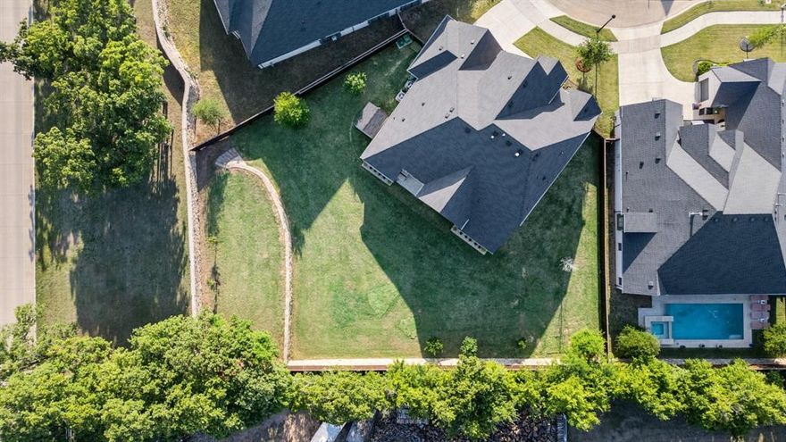 Welcome to 318 Waters Edge Drive – a contemporary retreat of style and substance nestled in one of Argyle’s most tranquil and sought-after communities. Built in 2020, this thoughtfully designed Coventry residence offers 3,448 square feet of sophisticated living, featuring an open floor plan, luxurious upgrades, four bedrooms, four bathrooms, and a dedicated private office—ideal for working from home or enjoying a quiet escape.

At the heart of the home, a custom sliding glass wall creates a seamless connection between the open-concept living area and the expansive covered patio, inviting effortless indoor-outdoor living. High-end finishes, clean architectural lines, and abundant natural light elevate the home’s modern aesthetic while providing an inviting ambiance for both relaxation and entertaining.The expansive primary suite is a luxurious sunlit retreat, complete with a spa-inspired bath featuring a deep soaking tub, a custom walk-in shower with a rain-shower head and multiple body sprays, and refined finishes that evoke everyday serenity.

Purposefully designed for multigenerational living, the layout also includes a private secondary bedroom suite on the main level—ideal for extended family, guests, or live-in support—offering both comfort and independence.

Set on a beautiful half-acre lot, the backyard is a true extension of the living space. The spacious patio, plumbed for water and gas, provides the perfect foundation for your dream outdoor kitchen or tranquil garden escape. Whether hosting al fresco dinners or enjoying quiet evenings under the stars, this home adapts beautifully to your lifestyle.

Perfectly positioned near top-rated Argyle ISD schools, upscale shopping, dining, and with easy access to major highways and DFW International Airport, this property blends peaceful living with exceptional convenience.

318 Waters Edge Drive invites you to experience modern luxury reimagined—where every detail is curated for elevated everyday living.