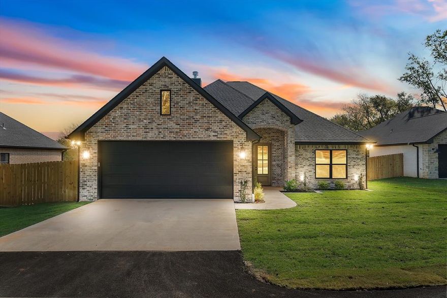 Over half an acre. No city taxes. No HOA. No PID. A combination increasingly hard to find and even harder to replace.  This brand new home sits on a 0.57 acre fully usable lot in Fullingim’s Haven at Mill Run, offering space, flexibility, and lower ongoing ownership costs while remaining conveniently close to Athens amenities. Inside, the open concept layout is filled with natural light and anchored by a stone, wood burning fireplace that creates a warm focal point in the main living area. Engineered hardwood flooring runs throughout, leading into a seamless kitchen with granite countertops, a large island, high end cabinetry, decorative lighting, and a walk-in pantry, designed for everyday living and entertaining. Built with modern construction standards, energy efficiency, and a 1-2-10 builder warranty, this home provides peace of mind rarely found in resale properties.
The split bedroom floor plan offers privacy and versatility. The primary suite features dual vanities, a soaking tub, separate shower, and an oversized walk in closet, while secondary bedrooms are well sized for guest space, a home office, or flexible use.  Outdoor living is enhanced by a covered back porch and fenced backyard with a 6 foot privacy fence, with the lot extending beyond the fence line providing additional usable space for future customization such as a garden, shop, or expanded outdoor living (buyer to verify). Lots of this size and usability are increasingly rare. The neighborhood includes deed restrictions designed to protect long term upkeep without HOA dues or oversight. Additional highlights include installed irrigation and high speed internet availability. Conveniently located near UT Health and Athens ISD, this home offers land, flexibility, and freedom an opportunity to secure space and long-term value in a market where homes like this are becoming harder to find.