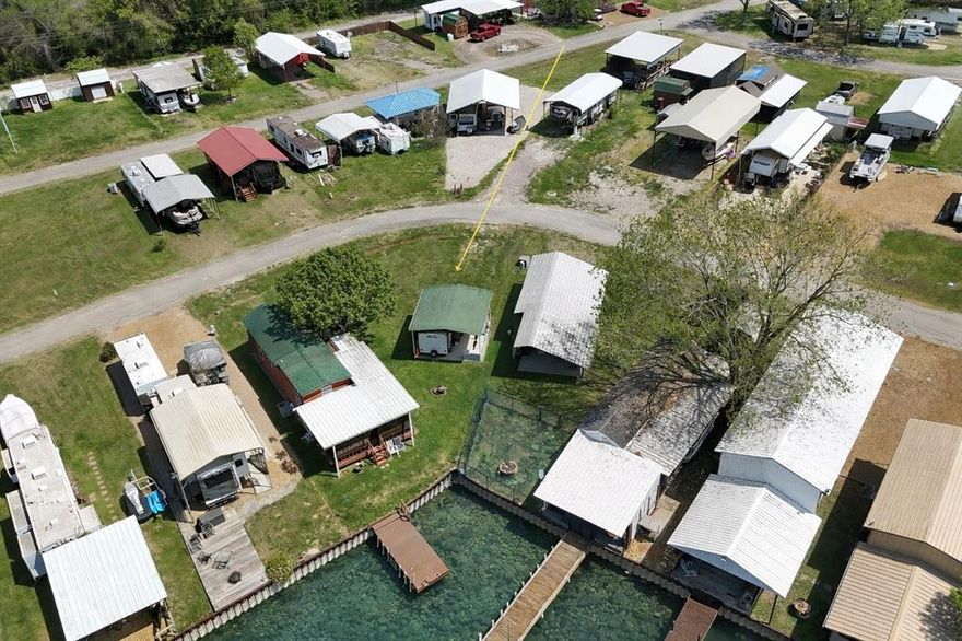 Small footprint, BIG lake life—now fully set up and ready to enjoy from day one! Welcome to this unique waterfront lot in the gated Pelican Isle community on Richland Chambers Lake, where everything is already in place for effortless “plug-and-play” recreation.

This improved lot features approximately 13 feet of shoreline with a steel retaining wall, giving you just enough waterfront to fish, launch a kayak, or unwind by the water. But what truly sets this property apart is that it’s not just land—it’s a ready-made getaway.

Included with the property is a travel trailer already positioned under a covered carport on a concrete pad, creating a comfortable and functional lakeside retreat. Inside, you’ll find a thoughtfully designed space with a sleeping area, dinette seating, kitchen setup with appliances, and a full bathroom—everything you need for weekend stays or extended escapes. It’s the perfect setup for those who want to enjoy lake life without the hassle of building or constant setup.  Trailer is a 2016 Dutchmen Aspen Trail and is 21.5 feet long.

Utilities are already installed, so you can pull in, plug in, and start relaxing immediately. Whether you're looking for a low-maintenance getaway, a fishing basecamp, or a simple place to recharge, this property delivers.

Located in a gated community with access to a private boat ramp, pool, clubhouse, park, playground, and fishing areas, you get all the perks of lake living in a compact, easy-to-maintain package.

No stress. No setup. Just show up and enjoy a slice of life at Richland Chambers Lake.