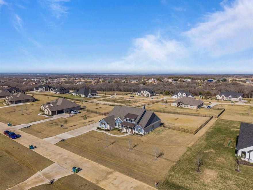 Welcome to luxury Texas living on a full acre in highly sought-after Gunter! This stunning single-story home offers 4 bedrooms, 3 full baths, a dedicated office, and a versatile media or game room that could easily serve as a 5th bedroom—each space thoughtfully designed with its own walk-in closet, including the office and media room.

Step inside to an open, inviting floor plan anchored by a gorgeous kitchen featuring an oversized island, double ovens, beautiful cabinetry, and an electric cooktop with a gas line already run—simply add a propane tank if you prefer cooking with gas. The spacious living room showcases a large stone wood-burning fireplace.

The private primary suite offers a spa-inspired bath with dual vanities, linen closet, soaking tub, large walk in closet and oversized walk-in shower

Enjoy quiet moments on the covered front porch—perfect for sweet tea in a rocking chair—or savor your morning coffee on the large covered back patio overlooking the expansive backyard. The home also features a spacious laundry room with beautiful tile flooring, a full wall of cabinetry, a folding counter, and a sink. All cabinets and drawers throughout the home are soft-close.

Loaded with thoughtful upgrades, including plantation shutters, electric shades in the living room, high-end carpet added after closing, and a wrought iron fence enclosing the backyard. The oversized garage features epoxy flooring, overhead storage racks, multiple additional outlets (including one dedicated for a fridge), and insulation in the walls, ceiling, and garage door. Additional insulation was also added between the game room and dining room, and between the living room and primary bedroom for enhanced comfort and sound control.

Outside, enjoy an extra-wide, extra-long driveway offering easy parking for multiple vehicles. With its spacious single-story layout, premium finishes, and one-acre lot, this home delivers both luxury and practicality—ready for its next owner to love.