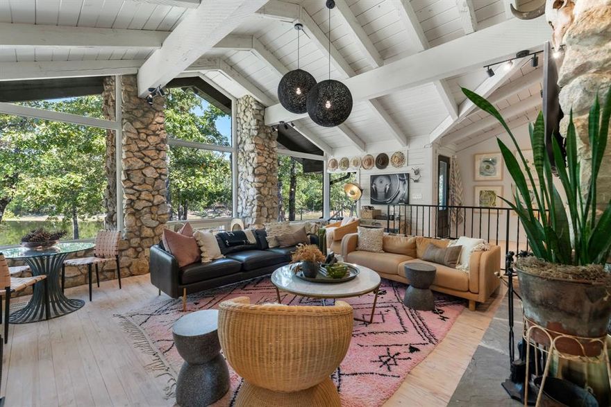 CURATED. BOLD. CHARMING. Nestled beneath a canopy of towering trees in the heart of East Texas, Limestone Hill Ranch is more than a ranch—it’s an experience. From the moment you pass through the private gates, a sense of calm settles in, & the pace of life slows. Where Round Top style meets bold architecture & timeless country charm, this reimagined midcentury modern log home is a masterclass in curation. Clad in sleek black & Austin stone, the residence makes a striking first impression, softened by natural beauty of its surroundings. The approach is magical: a winding driveway framed by dense woods, opening to a home that feels at once sophisticated & organic. The expansive front porch is its own living space, beckoning for slow mornings & lingering evenings. Inside, sky-high cathedral ceilings w exposed beams, massive windows overlooking the pond, & rustic stonework create a great room that inspires awe. Every space flows seamlessly—bar, dining, kitchen, & porch—designed for both intimate gatherings & grand entertaining. The kitchen, bathed in light from soaring ceilings & a skylight, continues the theme of bringing the outdoors in. The split-bedroom layout offers privacy & function: a primary retreat & bunk room (or office) on one wing, two guest suites on the other. The primary bedroom is a sanctuary of its own, w vaulted beams, another Austin stone fireplace, & a spa-like bath. An additional den provides a cozy hideaway, perfect for fireside evenings & movie nights. Every detail of the home has been curated w rustic Texas flair, blending chic design & authentic character. Beyond the walls, the land invites exploration: a private trail system winds past the pond, leading to serene back acreage. A stone firepit overlooking the water is ideal for morning coffee or wine & s’mores beneath the stars. Practicality meets luxury w a backup generator, improved grasses in the front meadow (ideal for a 3±AC pasture), & furnishings available separately for turnkey move-in.