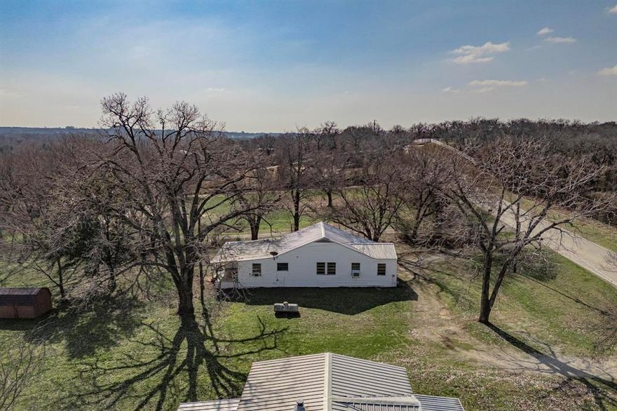 Move in ready home on 5.24 acres of peaceful flat land. 2 bedrooms, 1 bath, 2 living areas, dining room, laundry room, and front and back porches.  This home is now vacant after having a long-term tenant at $800.00 monthly.  The mobile home next to it currently has a 12 year renter on a month to month lease at $800 monthly. The owner occupying the home works as well while collecting rent on the other dwelling.
The mobile home is on a non-realty addendum including its specs in supplements. This property is ideal for collecting $1,600 monthly in rental income while building a home or placing a mobile home on the remaining 4.75 acres.  No excavation is needed, as this peaceful flat land is ready for your ideas. The heat and AC are provided by sufficient window units.
The refrigerator and stove come with the house.