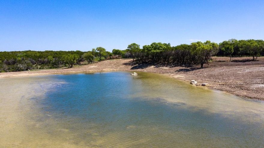 New water development! Existing canyon transformed into a spectacular 2-acre lake. Part of the historic V-Bar Ranch. Large acreage, seclusion, and varied terrain make this a covetable recreational or ranching property.  Heavily wooded with live oaks and other hardwoods, the elevation changes create beautiful scenic views and potential building sites.  Current owner has made extensive investment in developing this property for its recreational potential including cedar clearing, road development, water development and boundary fencing for livestock.  Amongst the rock cliffs and canyons, this property includes open meadows with good soil that produce strong native grasses good for livestock or food plots.