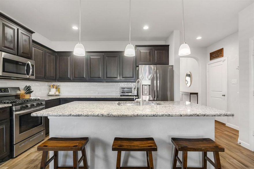 Welcome to this beautifully maintained home completed in 2019, offering 2,109 square feet of thoughtfully designed living space in the highly sought-after Oak Creek Trails community. This 3-bedroom, 2-bath stunner sits just off Highway 114 in North Fort Worth, providing easy access to Northwest High School, Texas Motor Speedway, Tanger Outlets, Buc-ee's, and the Golf Club at Champions Circle—everything you need is right at your fingertips.

Inside, you'll love the open-concept floorplan that's perfect for modern living and entertaining. The kitchen features a large island with granite countertops, a gas cooktop, and an on-trend backsplash that was updated in 2023. Gorgeous wood-look tile flooring flows throughout the main living and dining areas, delivering both style and durability for everyday life.

The primary suite is a true showstopper—extra spacious with plenty of room to add a sitting area or home office setup. The smart split floorplan places two secondary bedrooms on a separate hallway for maximum privacy, while a versatile bonus room at the front of the home can serve as an office, playroom, or guest suite. Just off the entrance, you'll find a convenient mud bench and an expansive walk-in closet, giving you all the storage options you need.

Outside, the covered patio is ready for Texas game days, family cookouts, and outdoor entertaining. Complete with a TV mount and plenty of space for your patio furniture and grill, this is where memories are made on those perfect weather days.

With its prime location near top-rated schools, major highways, shopping, and entertainment, this home delivers the complete North Fort Worth lifestyle package. Don't miss your chance to make it yours.