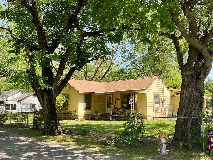 This 1,178 sf house sits on almost half an acre and has 2 bedrooms and 1 bathroom.  The front room (living) is currently set up as a bedroom.  The lot is very spacious and has huge pecan trees.  There is a 21 x 23 workshop with electricity.  Plenty of room for the kids to play and the pets to run around.