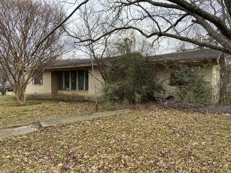 .34 ac DOUBLE SIZE LOT in town with utilities on property. Has not been n use for many years and not much value in the home however, property could be remodeled or torn down for an even better custom home building site.  Property once entertained one of the best gardens along with fruit trees being peach, and plum and a 50 yr old pecan tree that the seller planted as a child.  A very large mature Crepe Myrtle tree accents the front yard. Value in the home is questionable and entering is done at your own risk.   Buyer and or Buyer Agent to verify all information.