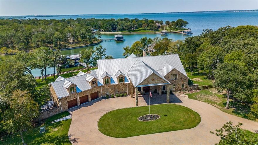 Escape to your own private oasis on the shores of Richland Chambers Lake. Situated on 4.2 acres with over 500 ft of shoreline, this exquisite home is designed for both relaxation and entertainment. The open floor plan boasts soaring beamed ceilings, a majestic stone fireplace, and a gourmet kitchen with top-of-the-line Wolf and Sub-Zero appliances. With 5 bedrooms, 5.5 baths, a game room, bunk rooms, office, and even an elevator, there's ample space for family and guests. Step outside to discover an outdoor paradise complete with a summer kitchen, screened patio, and balconies offering breathtaking lake views. The boat house features 3 boat lifts and a jet ski lift, all with automatic covers, ensuring effortless water access. For the sports enthusiasts, the property also includes a sport court with pickleball, basketball, & volleyball. Additional features include a shop with boat and toy garages and guest quarters. Don't miss the opportunity to own this one-of-a-kind lakefront retreat!