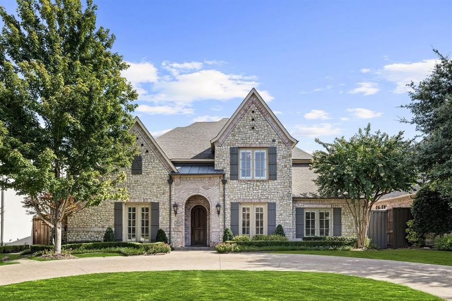 Architectural presence and everyday livability rarely meet this confidently, but this Preston Hollow home brings both together from the very first look, all in a location steps from Preston Hollow Park, the most shaded park and very best park Dallas has to offer. The circle drive curves through meticulous landscaping toward a façade that feels intentional and refined. Inside, natural light climbs the tall ceilings and settles across the entry, illuminating the formal dining room to the right and the dedicated office to the left. The sweeping staircase becomes its own design moment before the home opens into the living room; a space shaped by sunlight, a beautiful stone fireplace, a built-in entertainment center, and a full wall of windows that blur the line between indoors and the backyard beyond. The kitchen carries the same level of detail with beautiful countertops, white cabinetry, a center island, and stainless appliances including a JennAir 6-burner gas cooktop and built-in double oven. It’s designed for real cooking, but also for the kind of gathering that happens naturally around a well-appointed workspace. The main-floor primary suite sits with quiet confidence, offering direct access to the backyard. Its ensuite elevates the everyday with a chandelier, soaking tub, separate vanities, and a walk-in shower. A second bedroom on this level adds comfort for guests or multigenerational needs. Upstairs, the home expands into a game room, media room, exercise room, 2 additional bedrooms, and a balcony that frames the view of the backyard. The outdoor space is its own destination. A covered patio with a gas hookup supports everything from quiet dinners to weekend gatherings, and the saltwater pool and spa bring a resort-level layer to the experience. The yard is also plumbed for a fire pit, giving you room to shape the space even further. The more time you spend here, the clearer it becomes that this home was designed to exceed expectation!